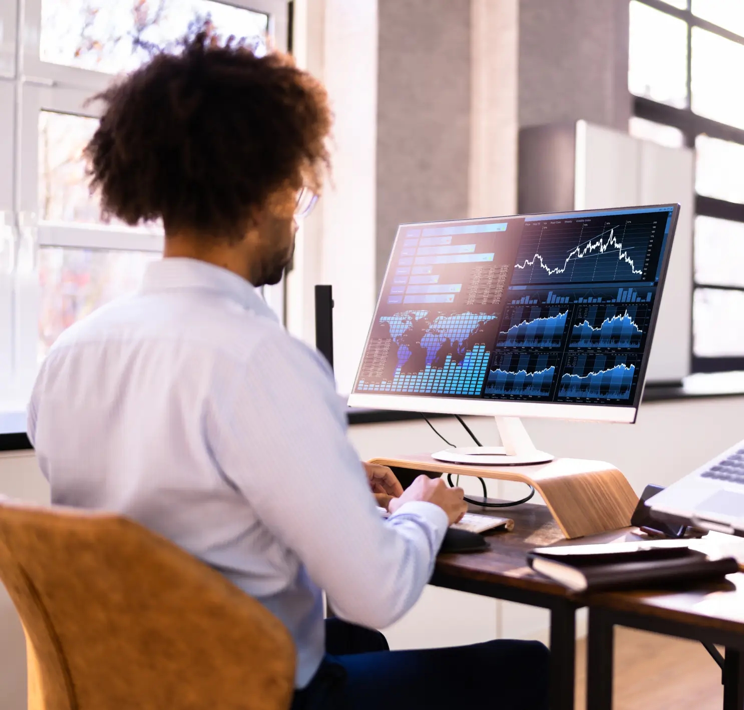 Image showing a person analyzing data on a computer screen, with charts and graphs, representing digital monetization strategy development