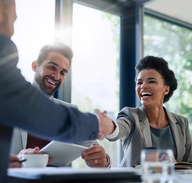 Two business people shaking hands at a meeting, symbolizing resource scaling partnership